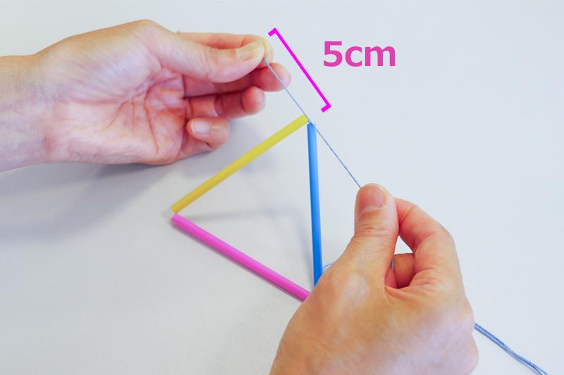 針に糸を通して8cmのストローを3本つなぎ、針側ではないほうの糸が5cmほど残るところで、三角形を作って固結びする。