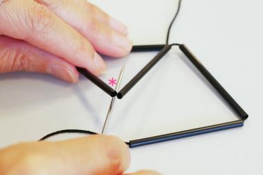 さらに5cmストロー２本を糸に通し、②で作った正三角形の＊位置の下から針を通して糸を掛ける