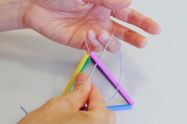 糸で輪を作って、三角錐の頂点の下から針を輪の中に通す